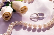 white roses, wedding rings and pearls