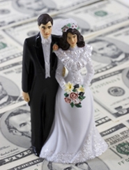 bride and groom figurine on stack of money