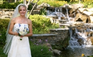 bride posing by waterfall